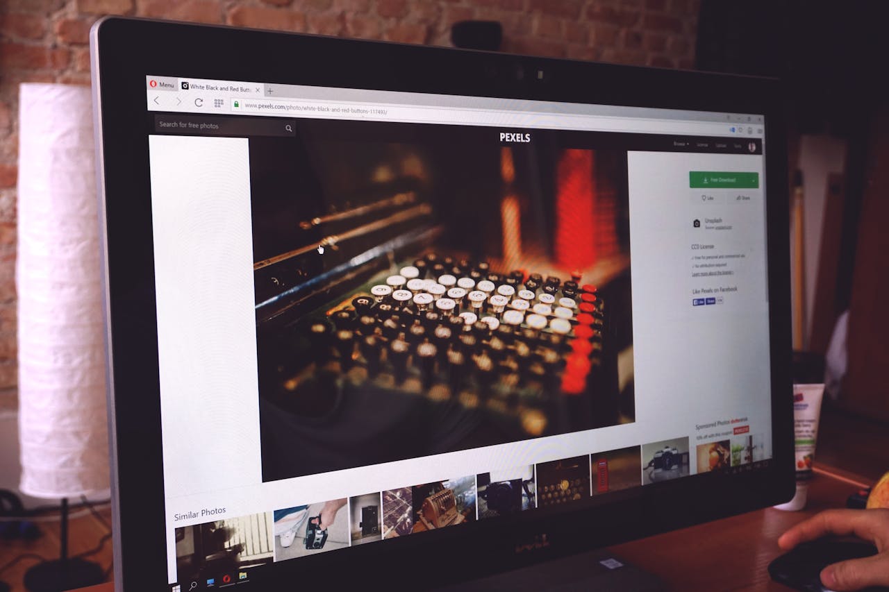 A modern desk setup with a computer monitor displaying an image of a vintage typewriter, highlighting a work environment.